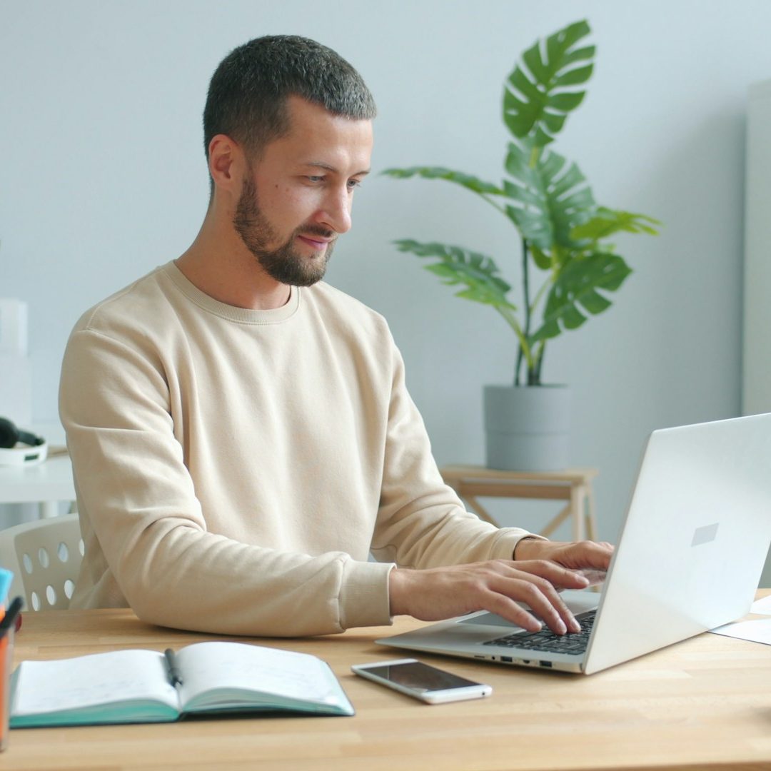 Person am Laptop Das Foto zeigt einen Mann, der an seinem Laptop arbeitet.