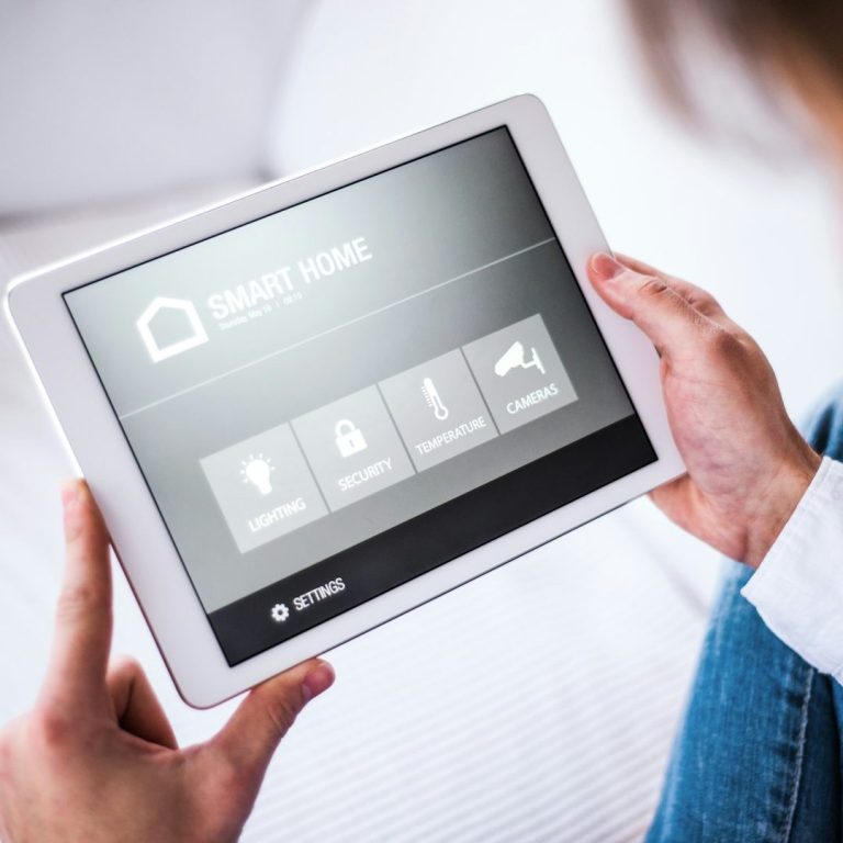 Tablet mit Steuerungselementen für ein Smart Home-System in einer Hand.